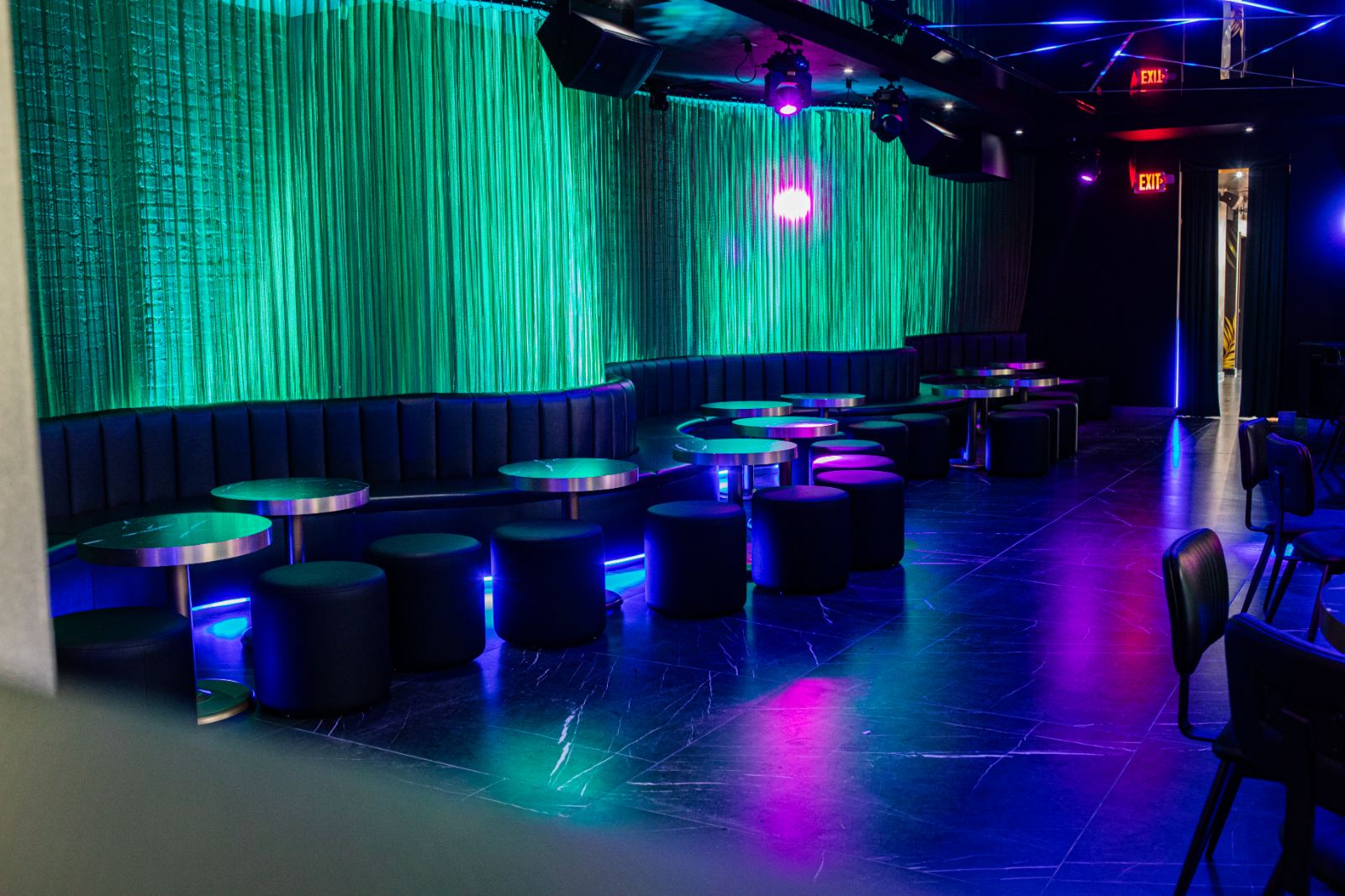 Elevated lounge with green curtain banquettes